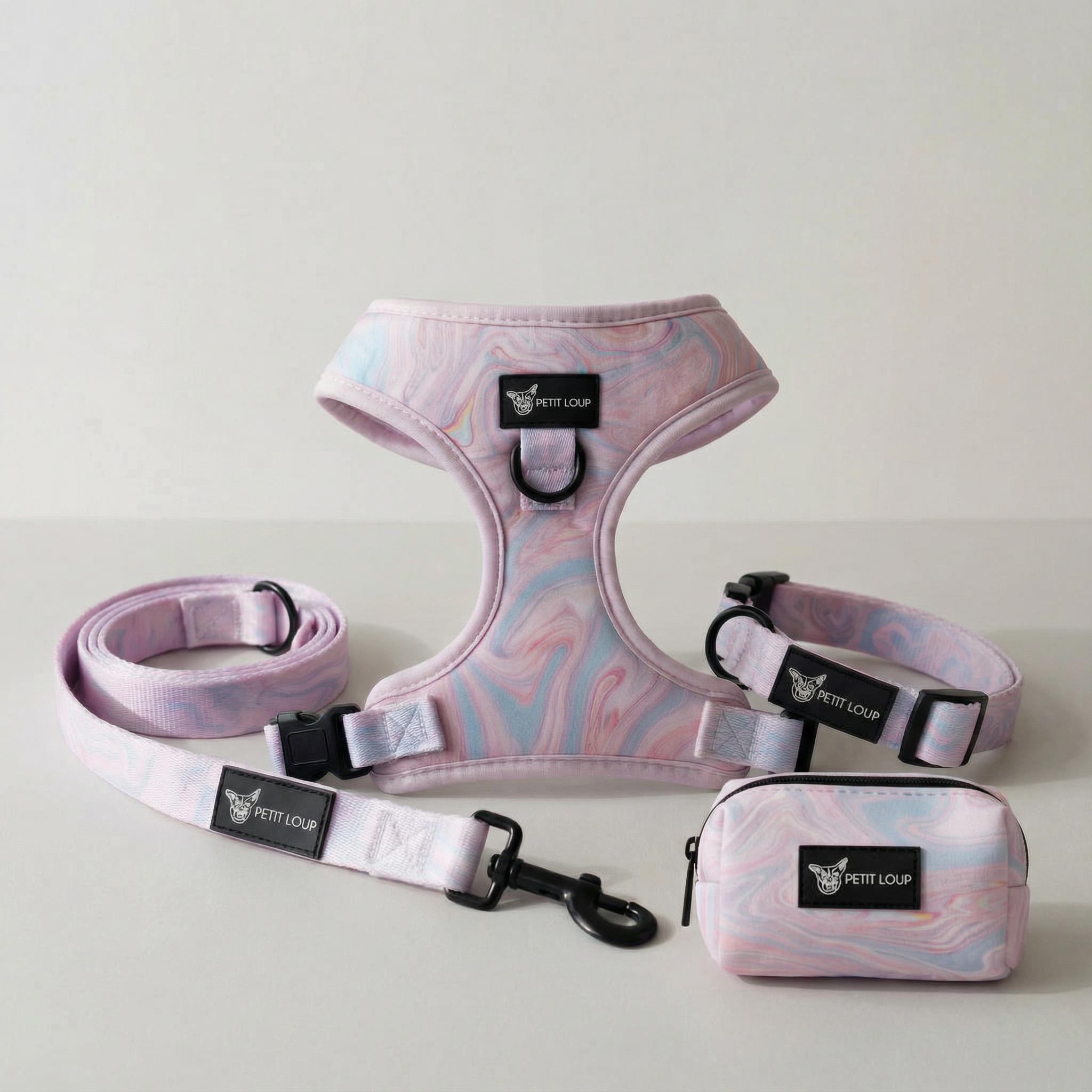Dog harness, leash, and pouch set with pink and blue marbled pattern on a light gray background.
