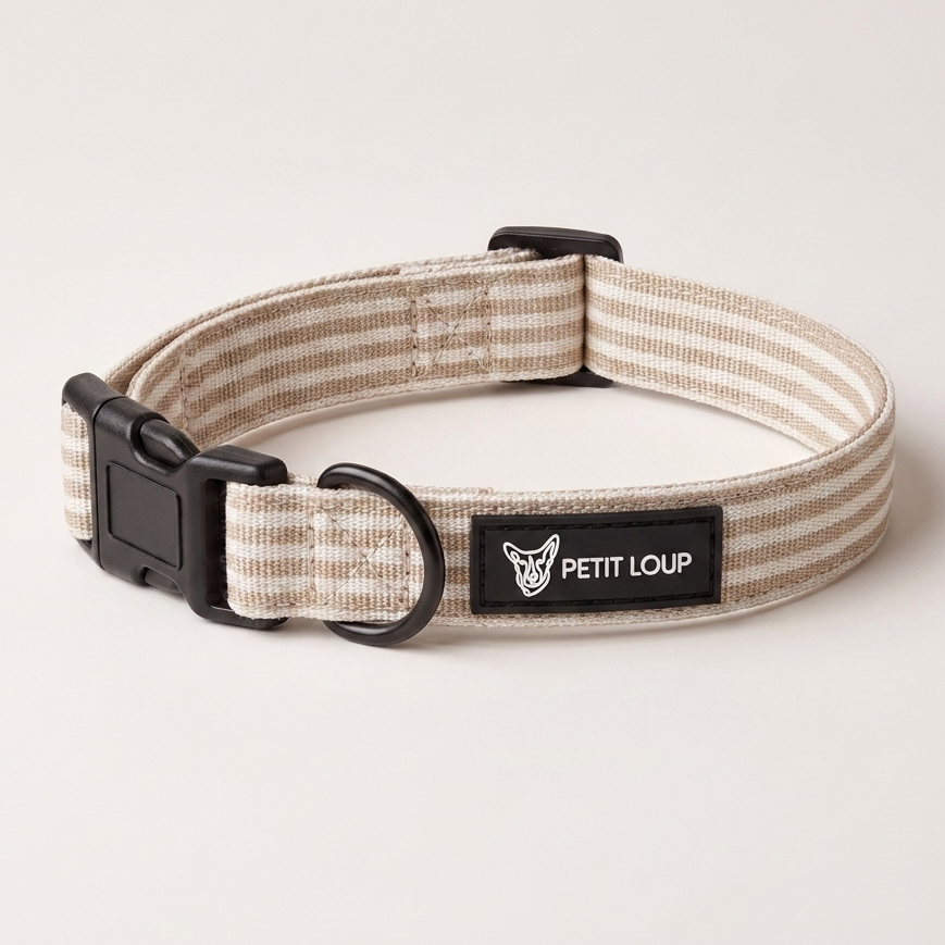 A striped fabric dog collar with beige and off-white horizontal lines, black plastic hardware, and a black brand label reading 'PETIT LOUP'.